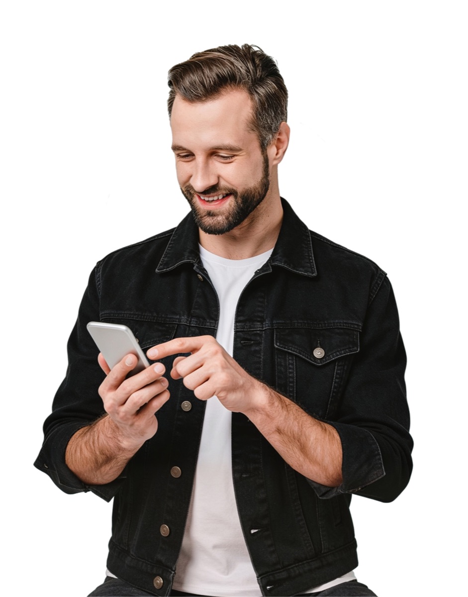 Homem sorrindo enquanto usa o celular